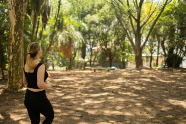 Genç bir kadın parkta koşuyor ve koşuyor. Spor yaparken bayan sporcu. İyi, sağlıklı bir konsept. Yüksek kalite fotoğraf