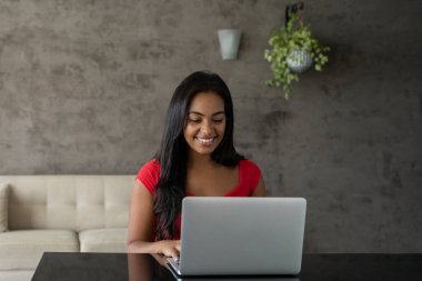 Masasında dizüstü bilgisayarla çalışan genç siyahi bir kadın. Merkez ofis konsepti. Çalışmak için gri defter. Yüksek kalite fotoğraf