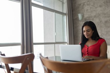 Masasında dizüstü bilgisayarla çalışan genç siyahi bir kadın. Merkez ofis konsepti. Çalışmak için gri defter. Yüksek kalite fotoğraf