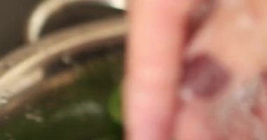 Mutfakta vejetaryen yemeği hazırlayan mutlu ve sağlıklı genç adam yemeği. Yüksek kaliteli video. İyi, sağlıklı ve sağlıklı hissediyorum..