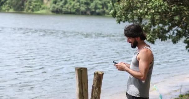 年轻的商人拿着智能手机在一个绿地公园里干活 总部的概念 高质量的录像 — 图库视频影像
