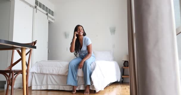 若い黒人女性が家で働いていて スマートフォンが寝室のベッドの上に座っている ホームオフィスのコンセプト — ストック動画