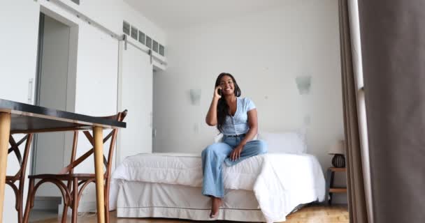 Jonge Zwarte Vrouw Werkt Thuis Met Smartphone Zittend Haar Bed — Stockvideo