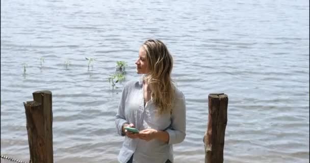 Mujer Blanca Joven Usando Teléfono Inteligente Durante Día Con Parque — Vídeo de stock