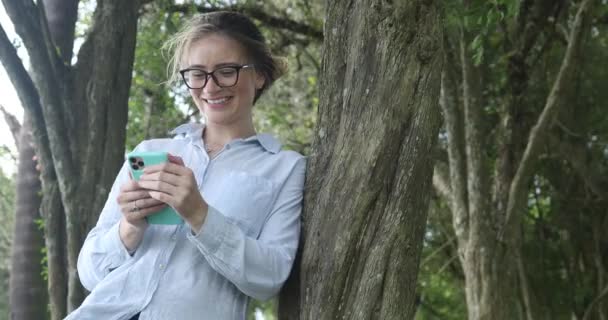 Fiatal Fehér Használja Okostelefon Nappal Egy Zöld Park Háttérben Kiváló — Stock videók