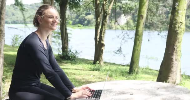 Молода Біла Жінка Використовує Ноутбук Вдень Зеленим Парком Задньому Плані — стокове відео