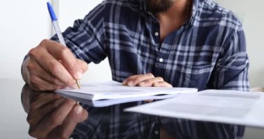 Masasında dizüstü bilgisayarla evde çalışan genç beyaz bir adam. Merkez ofis konsepti. Çalışmak için gri defter. Yüksek kaliteli video