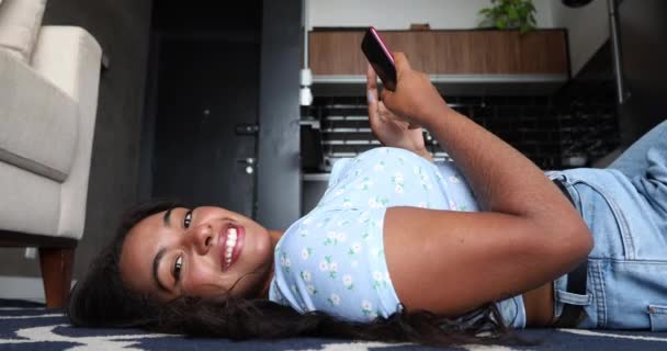 Jonge Zwarte Vrouw Thuis Met Smartphone Liggend Haar Keuken Woonkamer — Stockvideo