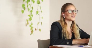 Evinde dizüstü bilgisayarıyla çalışan genç bir kadın. Merkez ofis kavramı.