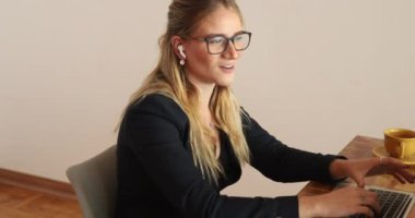 Evinde dizüstü bilgisayarıyla çalışan genç bir kadın. Merkez ofis kavramı.