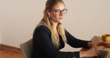 Evinde dizüstü bilgisayarıyla çalışan genç bir kadın. Merkez ofis kavramı.