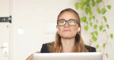 Evinde dizüstü bilgisayarıyla çalışan genç bir kadın. Merkez ofis kavramı.