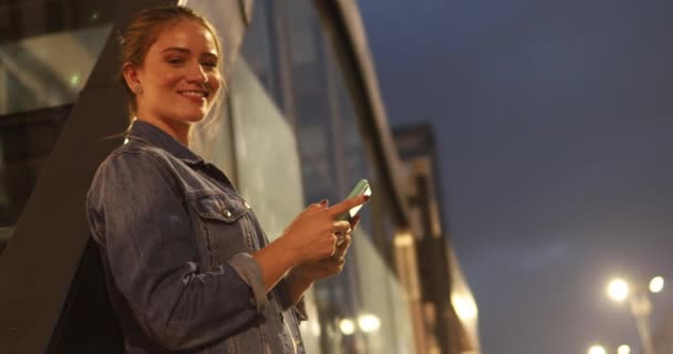 Young Woman Using Smartphone Nighttime City View Landscape Background — Stock Video