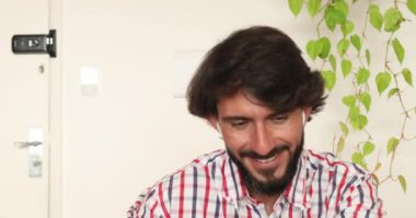 Evde çalışan genç bir işadamı çalışmak için defter tutuyor. Merkez ofis konsepti. Yüksek kaliteli video