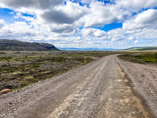 Estrada em linha reta no iceland que conduz a distante com um céu cloudy — Fotografia de Stock