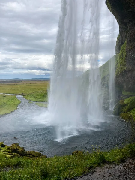 View from behind the falling Water of the Seljalandsfoss Waterfall in Iceland — Photo