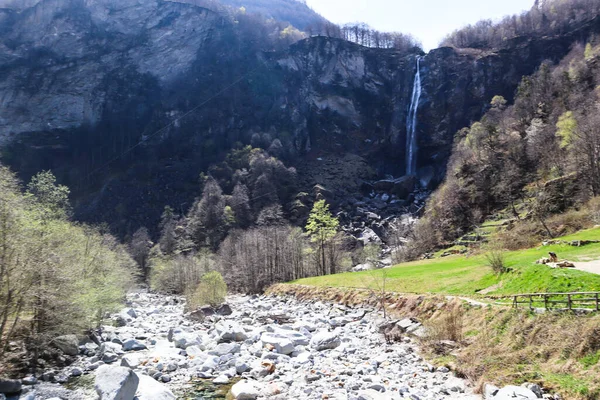 Foroglio, Switzerland, 12. April 2022: Foroglio Waterfall near the Village with old Stone Rustico Houses in Ticino. — Stockfoto