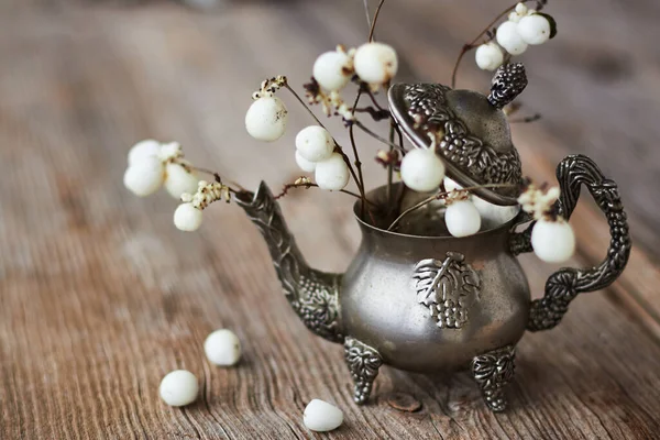 Dut ve minyatür gümüş çaydanlık dokulu ahşap bir yüzey üzerinde.