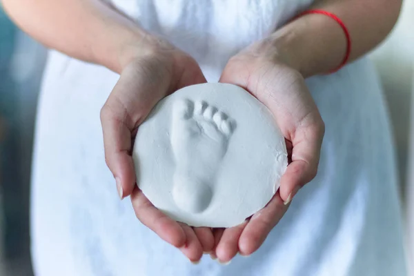 Bir bebeğin ayak izi, güzel bir kadının ellerinde, güzel bir hatıra için sevgiyle korunmuş.