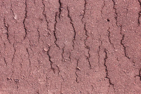 Asfalt bir yolun eski çatlak yüzeyinin dokusu ve alışılmadık rengi
