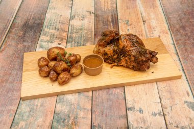 Kömürle kızartılmış yarım tavuk, çıtır çıtır deri ve bal sosu ve kavrulmuş taze patates.