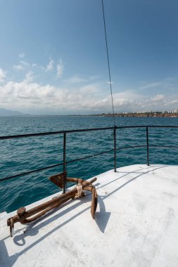 Bir tur teknesinin pruvasında demir demirler Akdeniz 'den geçiyor Antalya açıklarında Türk sahillerinde.