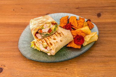 Kızarmış sebzeli kızarmış tortilla ile sarılmış tavuk sebzesi.