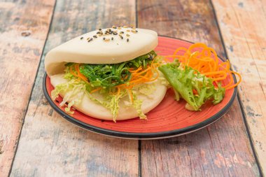 Japon bao ekmeğinin sebzeli sandviçi, yosun salatası, marul ve susam tohumlu rendelenmiş havuç ve haşhaşlı haşhaşlı.