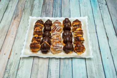 Bir tepsi siyah çikolatalı mini kruvasan, rendelenmiş beyaz çikolata ve rendelenmiş sütlü çikolata.