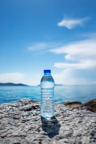 Botol Kecil Air Mineral Pada Beberapa Batu Oleh Laut — Stok Foto