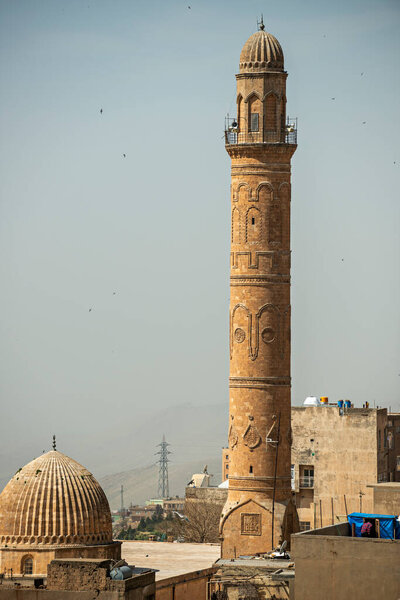 Monumental and beautiful sandstone minaret with bas-reliefs in the ancient city of Mardin