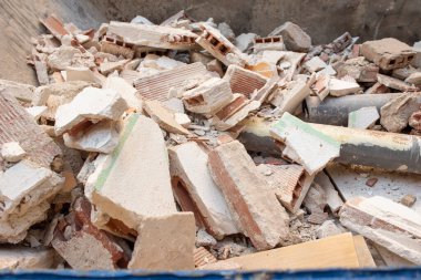 İnşaat atığı, pvc borular, metal bir konteynırın içine alçılı tuğlalar.