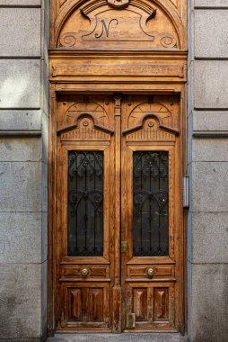 Gri granit bir binanın güzel ahşap giriş kapısı.