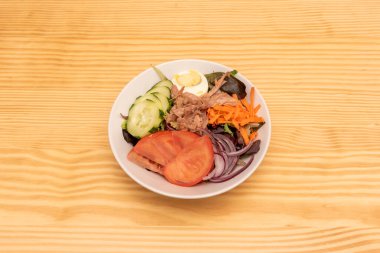 Meşe salatası, rendelenmiş havuç, çiğ kırmızı soğan, domates dilimleri, haşlanmış yumurta, konserve ton balığı ve zeytinyağlı çiğ salatalık dilimleri.