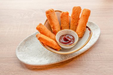 Buğday unuyla kaplanmış çedar peyniri çubukları, ekmek kırıntıları ve soslu yumurta.