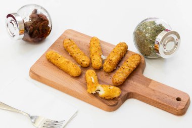 Kurutulmuş domatesli ve kekikli mozzarella çubuklarından oluşan aperatif tabağı.