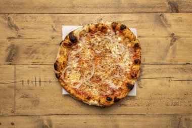 Domuz pastırması ve beyaz soğanlı pizzanın ahşap masada un hamuru.