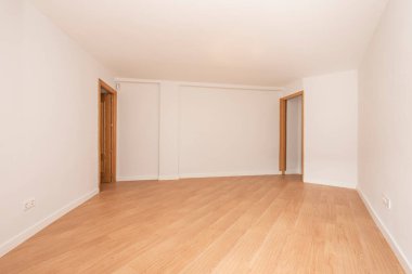 Meşe döşemeli, meşe kapılı ve çerçeveli beyaz boyalı oda.