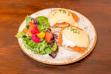 İngiliz çöreğinin iki yarısından oluşan Benedict usulü yumurta, Norveç somonu, haşlanmış yumurta ve çok popüler Hollandaise sosu.