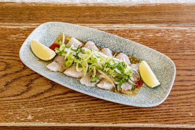 Sashimi, bir carpaccio kadar çok olmasa da ince dilimlenmiş çiğ deniz ürünlerinden veya balıklardan oluşan bir Japon yemeğidir. Bir sos ve rendelenmiş daikon turpu gibi basit bir sosla servis edilir.