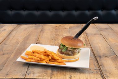 Eritilmiş peynirli sığır burger, keçi peyniri, roka yaprağı, salsa ve tatlı patates.