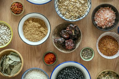 Ortası kurutulmuş noralarla dolu olan kaseler, yanında panela, paprika, kırmızı biber, Himalaya tuzu, kurutulmuş defne ağacı ve daha fazlası.