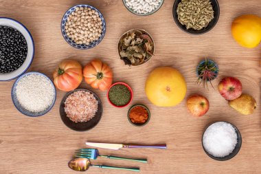 Greyfurt ve yuvarlak domateslerin deniz ve Himalaya tuzu, nohut ve pilav, dereotu ve paprika, elma ve hurma desenlerinin üst görüntüsü.