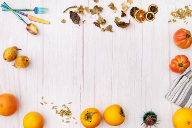 Resim çerçevesi mevsimlik meyveler ve kış baharatları ile beyaz tahta bir masa üzerinde yanardöner metal kaplamalı.