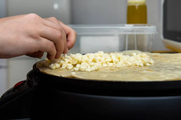レストランで提供するために塩辛いクレープからチーズを準備する女性シェフの手 — ストック写真