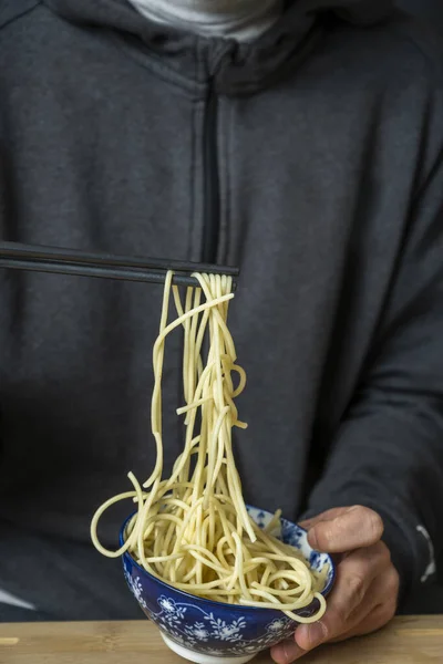 Kezében Spagetti Evőpálcikával Húzza Őket Egy Kék Tál Kezét Egy — Stock Fotó