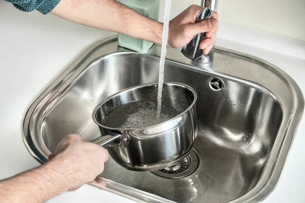 男の手は それが沸騰し 何かを調理するまで 実行中の水でステンレス鍋を充填 — ストック写真