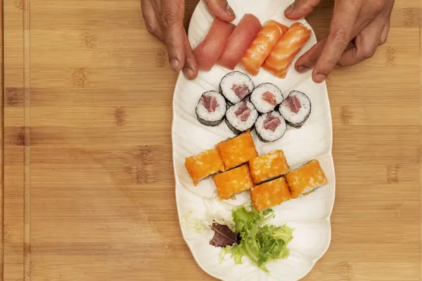 Ręce Szefa Kuchni Przygotowują Białą Tacę Sushi Maki Czerwonego Tuńczyka — Zdjęcie stockowe
