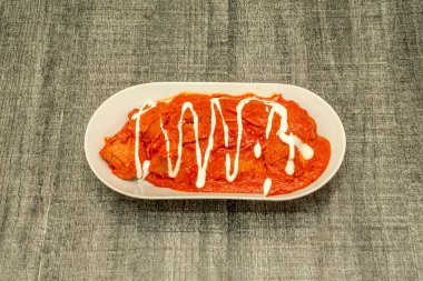 Hint tavuğu tikka masala sosu ve et suyu ile servis edilir. Değişkenlerin çoğu hindistan cevizi sütü veya kremalı domates sosunun yanı sıra farklı baharatlar içerir..