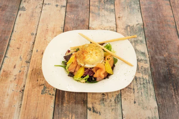 挪威鲑鱼沙拉 配以格拉丁山羊奶酪和橙子片 配以胡椒 — 图库照片